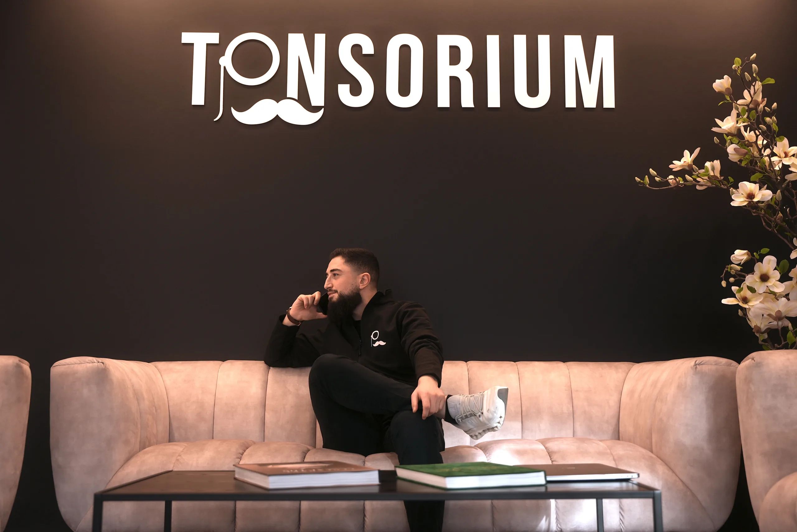 Lounge mit Sofa und beleuchtetem Tonsorium-Logo