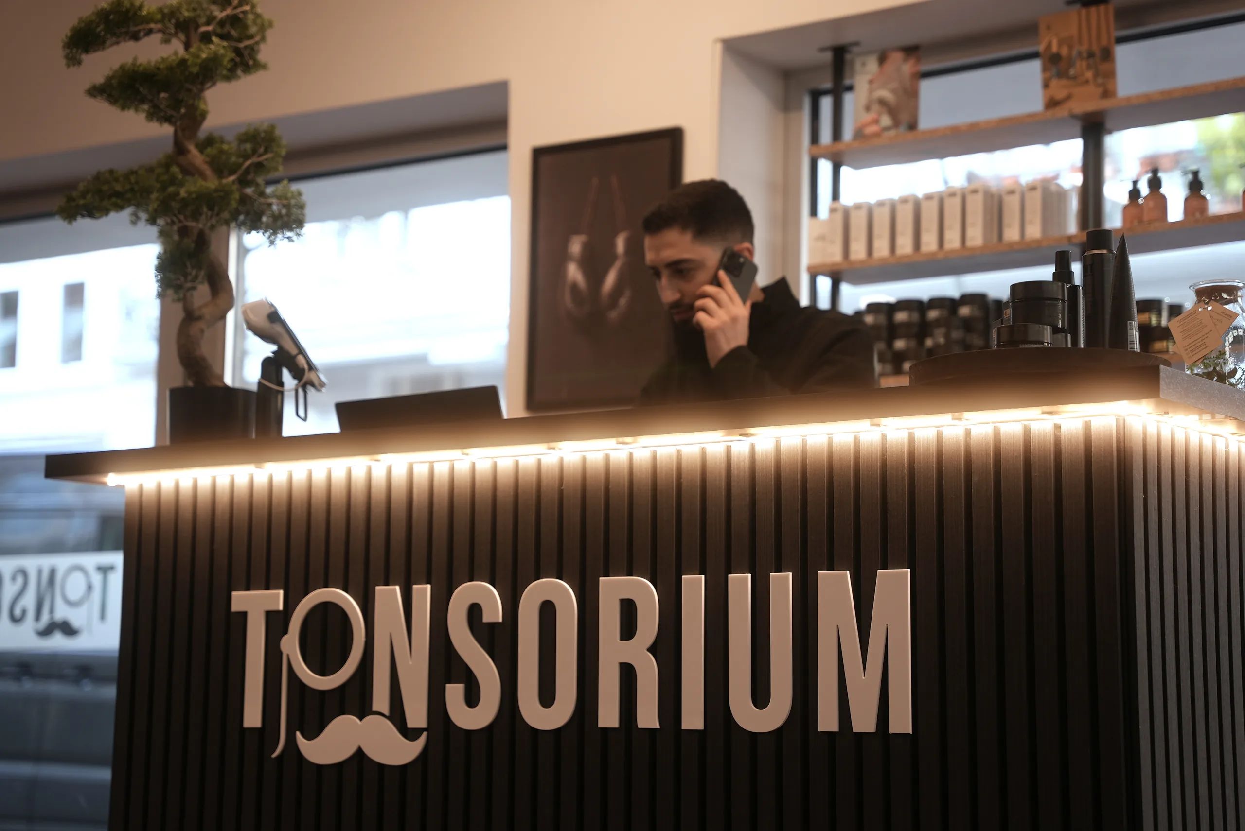 Empfangstresen mit beleuchtetem Tonsorium-Logo